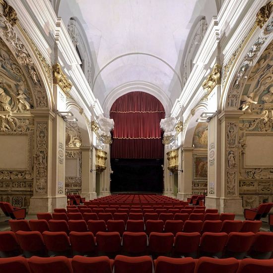 Кресла красного бархата под изображениями ангелов. Сегодня церковь Сан Фелипо в Аквиле – театр. Когда не хватает денег на реставрацию церквей, в Италии их продают в частную собственность.